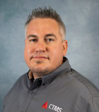 Justin Smialek in a blue suit, smiling confidently as a representative of Arizona auto dealers.